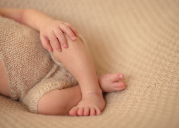 Crop baby lying crossed legs