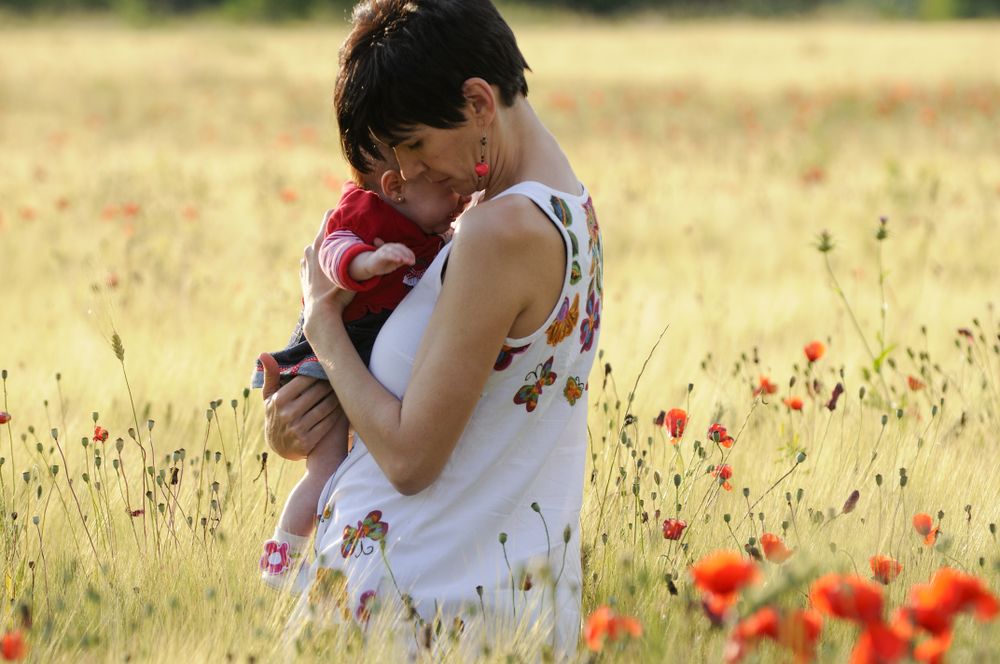 Mother holding daughter in field
