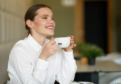 Smiling woman sipping coffee