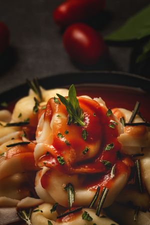 Plate of delicious ravioli with tomato sauce served on table