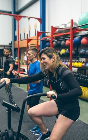 Sportswoman doing air bike at the gym
