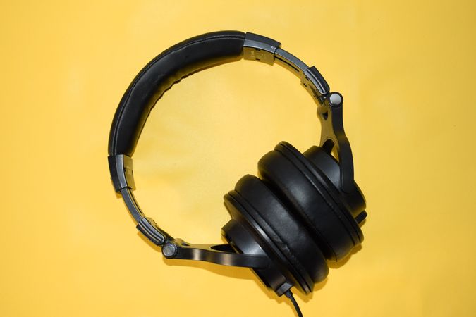 Headphones on yellow studio background