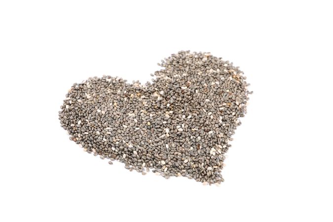 Heart laid out of chia seeds isolated on plain background