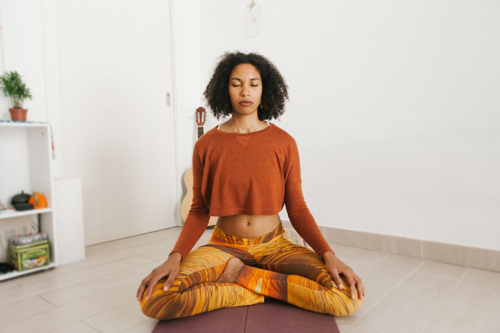 Sportive woman sitting in yoga pose with closed eyes
