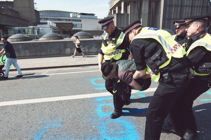 London, England, United Kingdom - April 19th, 2019: Police grabbing protestor spraying graffiti