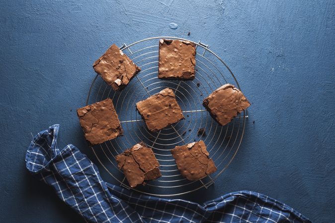 Chocolate brownies on a cooling tray on a blue tabletop