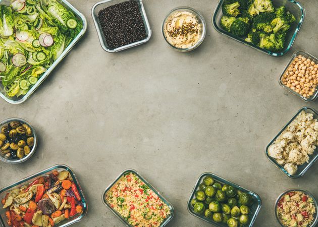 Variety of vegetable dishes arranged in glass containers, with copy space in center