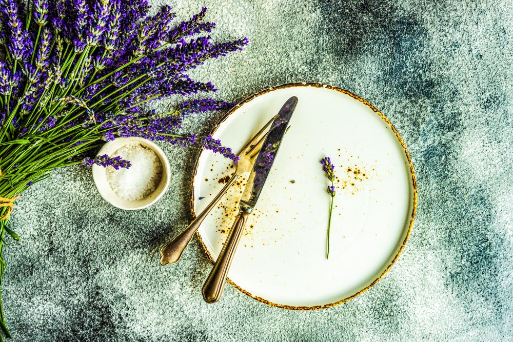 Top view of table setting with bunch of lavender and silverware