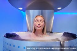 Blonde woman in cryotherapy chamber with eyes closed 5wXwxL