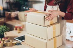 Woman with three boxes prepared for shipping