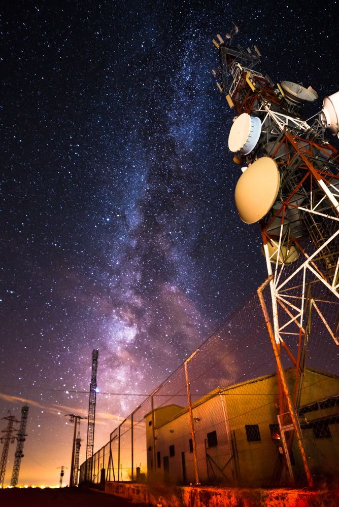 Amazing view of transmission towers against Milky Way in night sky