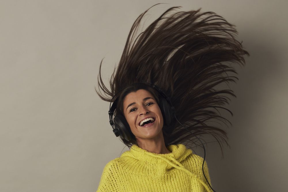 Shocked young woman listening to music in studio
