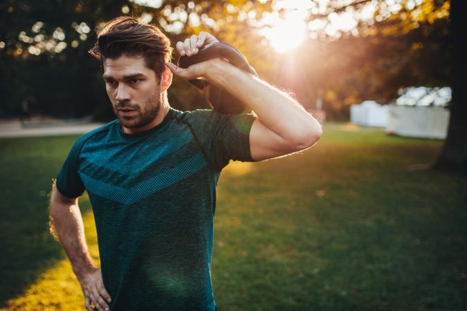 Portrait of strong young man exercising with kettlebell