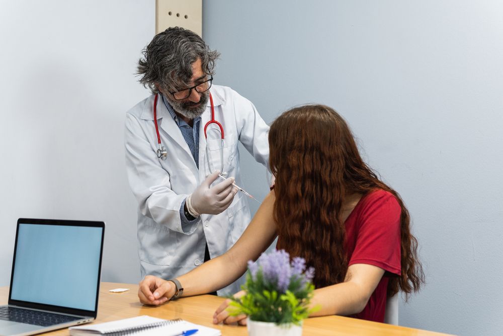 Doctor putting injection to woman patient