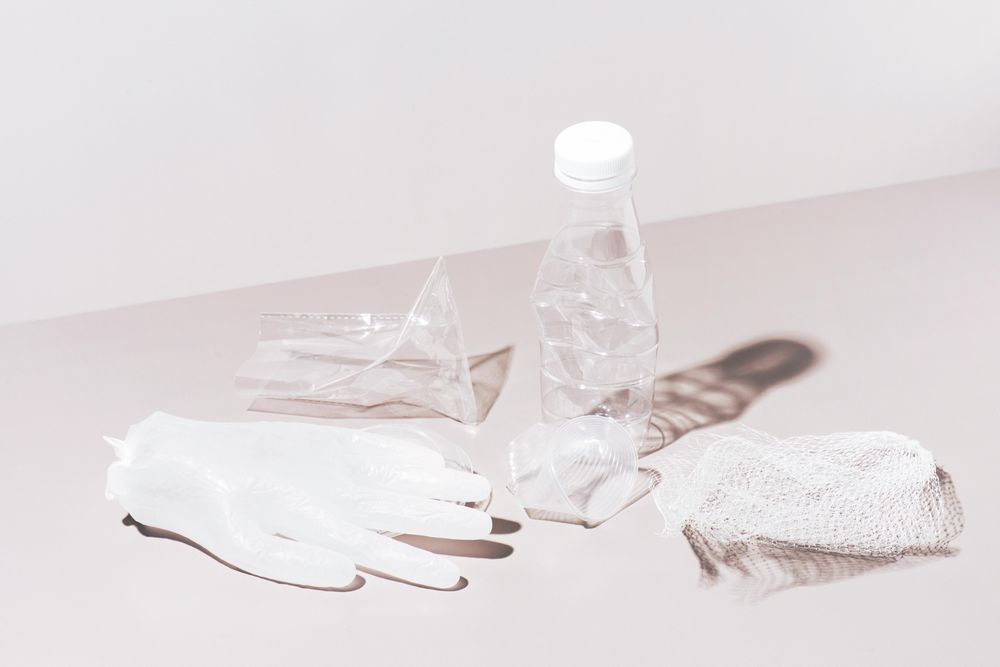 Various crushed plastic items on neutral background