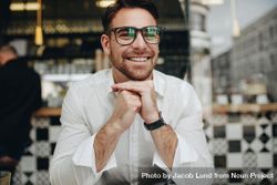 Man sitting in a cafe in relaxed mood and smiling bG22Y4