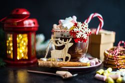 Side view of marshmallow hot chocolate on table with red lantern and ornaments