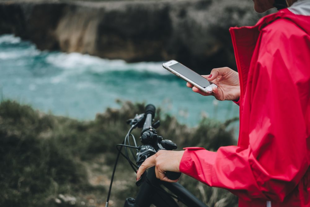 Anonymous female bicyclist using smartphone