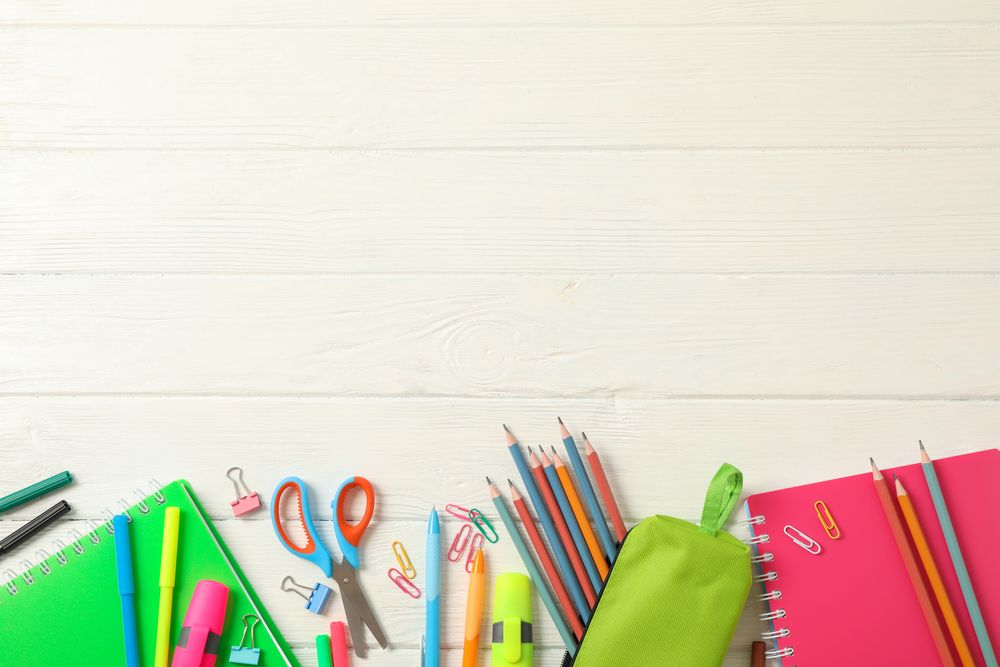 Flat lay composition with school supplies on wooden background, space for text
