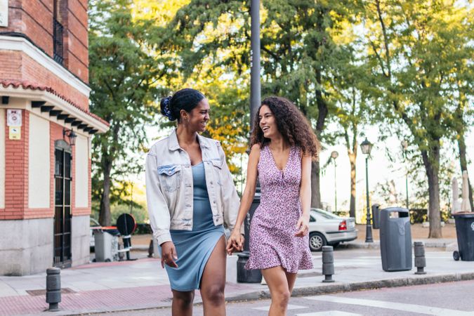Two women crossing the pedestrian crossing in the city.