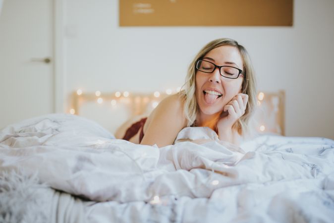 Woman making faces while lying in bed