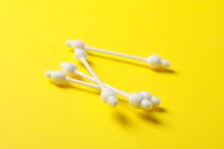 Baby ear sticks on yellow background. Hygiene