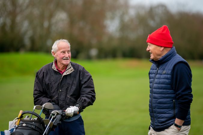 Two men walking on golf course with clubs