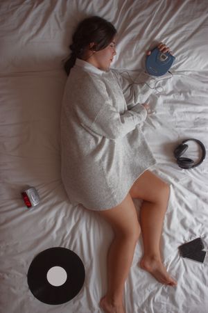 Woman listening to music and lying on bed