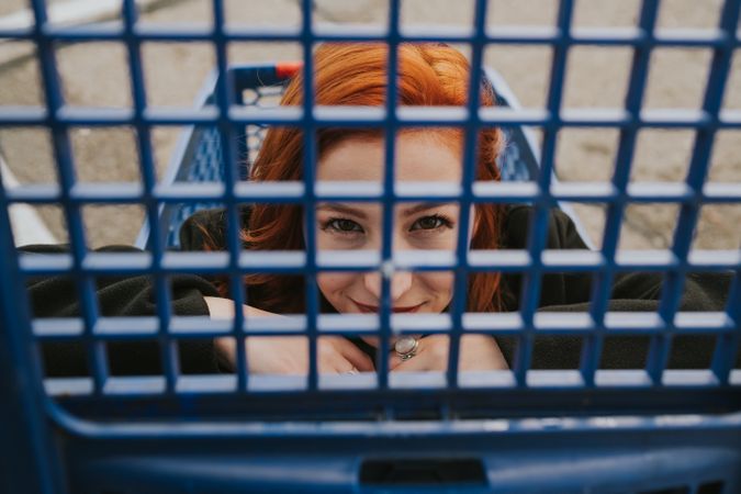 Woman looking through trolley grate in shopping cart