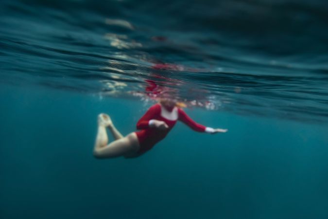 Woman diving in blue waving water