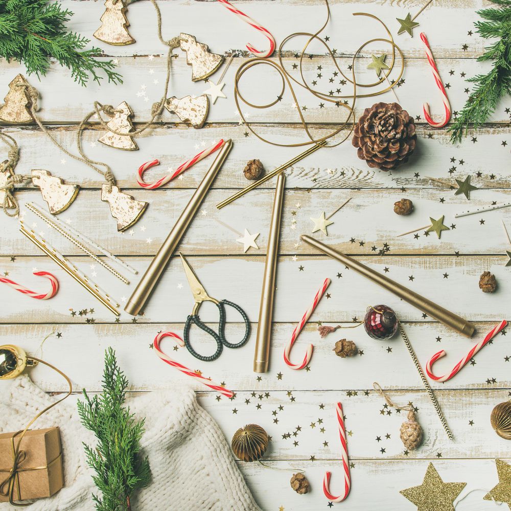 Decorations of stars, candy canes, scissors, candles on light background, square crop