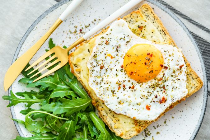 Delicious breakfast of fried eggs with toast and salad.