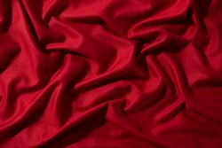 Crumpled wavy Red silky fabric background texture.