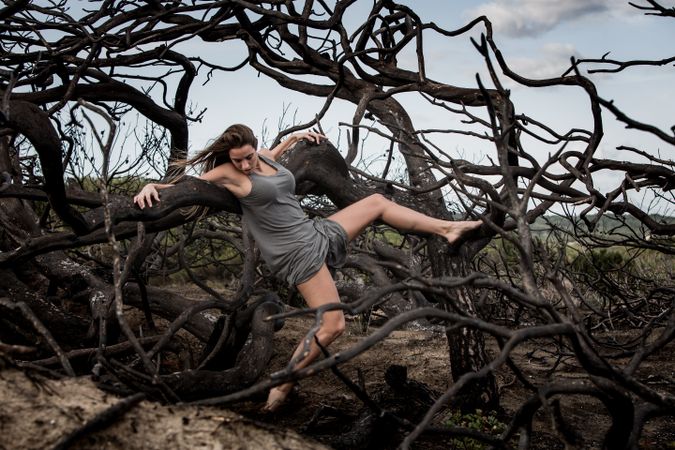 Woman posing on twigs of dry trees