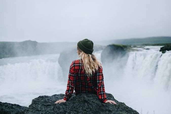 Back of woman sitting over waterfall