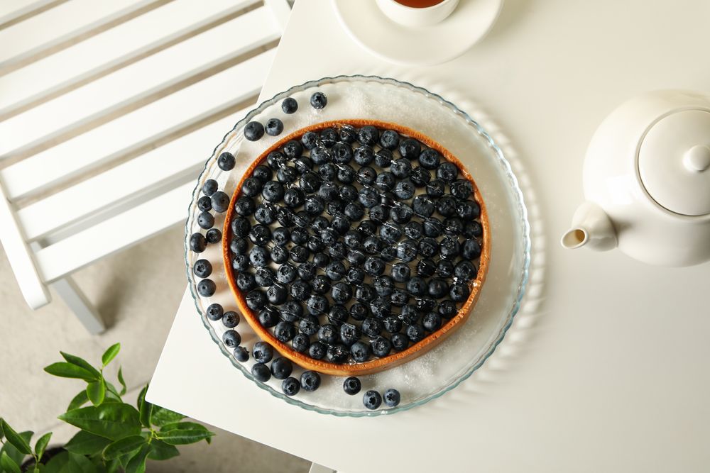 Concept of tasty breakfast with blueberry pie on table