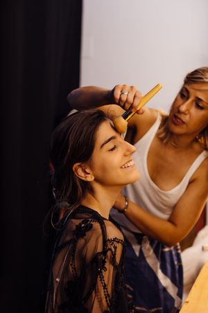 Makeup artist doing makeup for young female artist