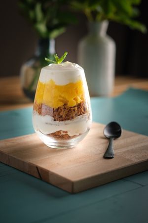 Layered cheesecake dessert in glass on table