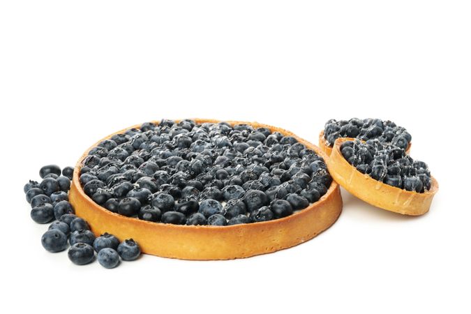 Tasty blueberry pies isolated on light background