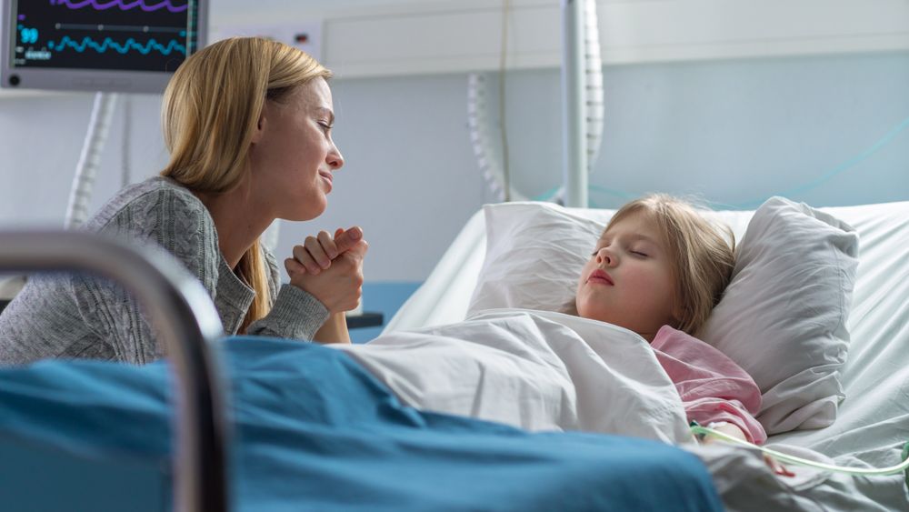 Cute Little Girl Sleeps on the Bed in the Children's Hospital, Her Mother Sits Beside, Worrying but Hopeful