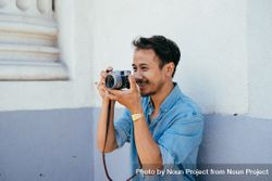 Male photographer smiling while taking a photo 5oDlQ4
