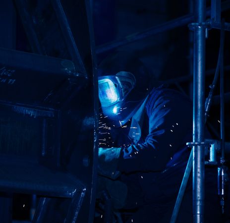 Professional welder in mask welding metal