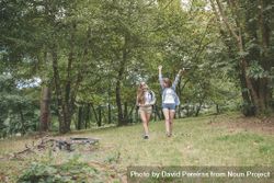 Female hiker raising arms and enjoying forest with friend 5oDWL9