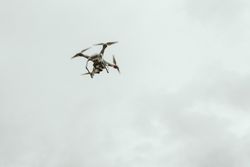 flying drone high in gray sky