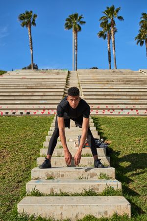 Hispanic man stretching on staircase
