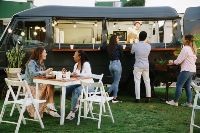 Food truck customers chatting with each other and vendor