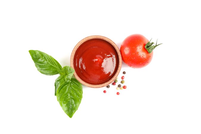 Fresh cherry tomato with basil, ketchup and spices isolated on plain background, top view. Ripe vegetables
