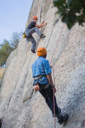 Climbers in safety harness climbing mountain