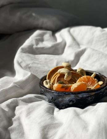 Health breakfast bowl on bedsheets in morning light