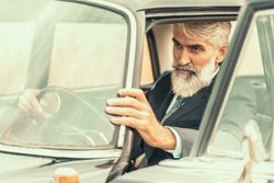 Man in suit driving car